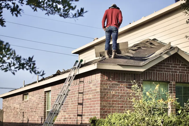 Professional roofer working on a residential roof in Camp Edwards
